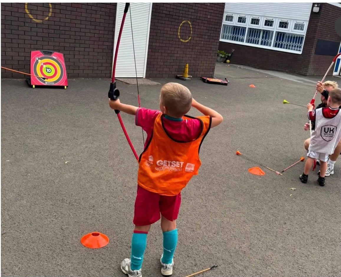 Child taking part in an archery activity at a UK Sports HAF camp