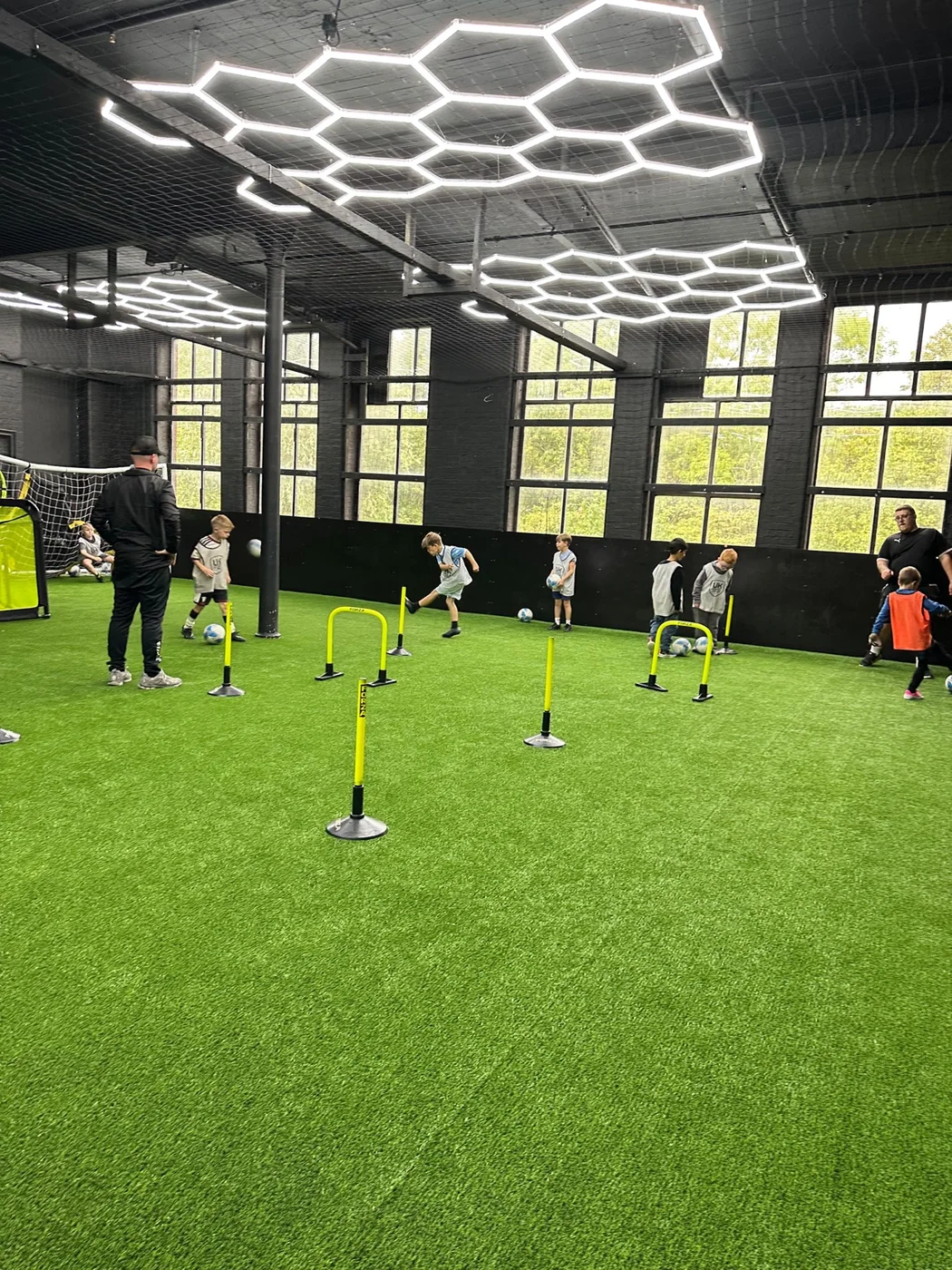 Children taking part in obstacle and ball activities in the UK Sports Arena at a birthday party