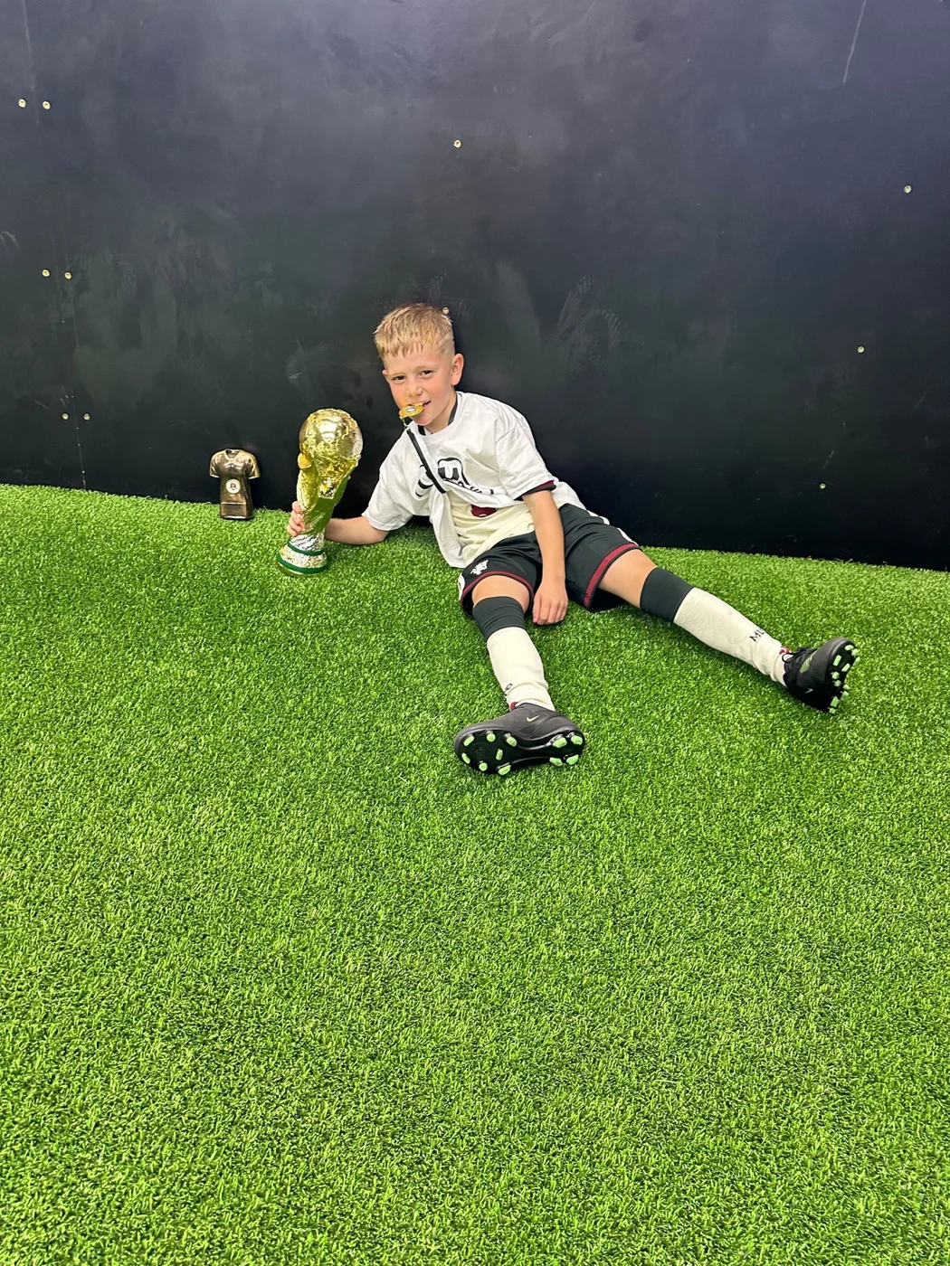Child holding a trophy at a UK Sports Coaching Ltd birthday party