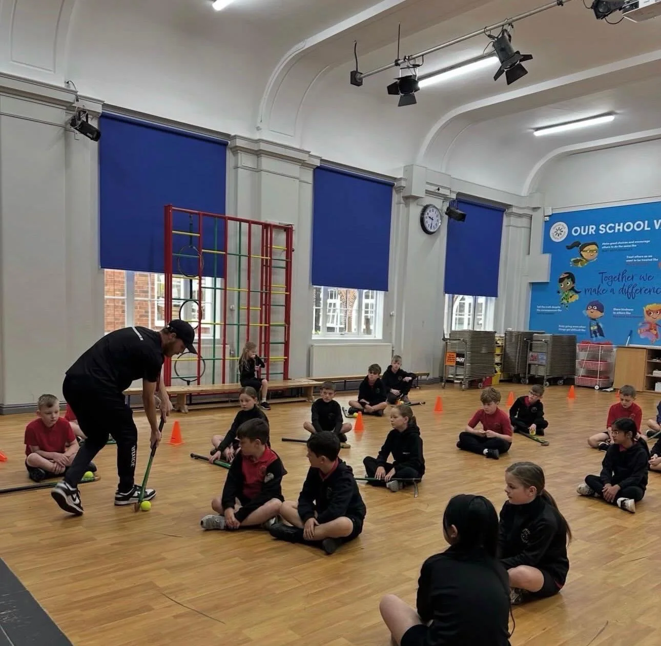 UK Sports Coaching Ltd delivering PE and hockey coaching in a primary school hall